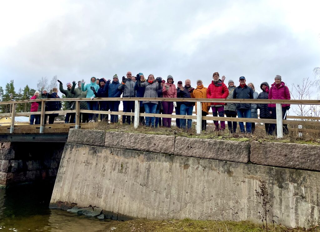Gruppbild med människor som står på en bro. 